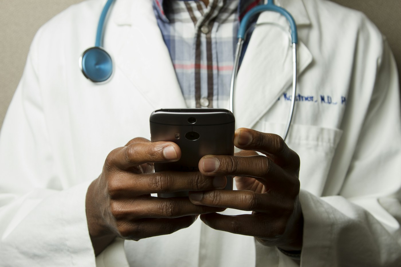 Stock photograph of a clinician holding a phone, not a Nickie client or patient